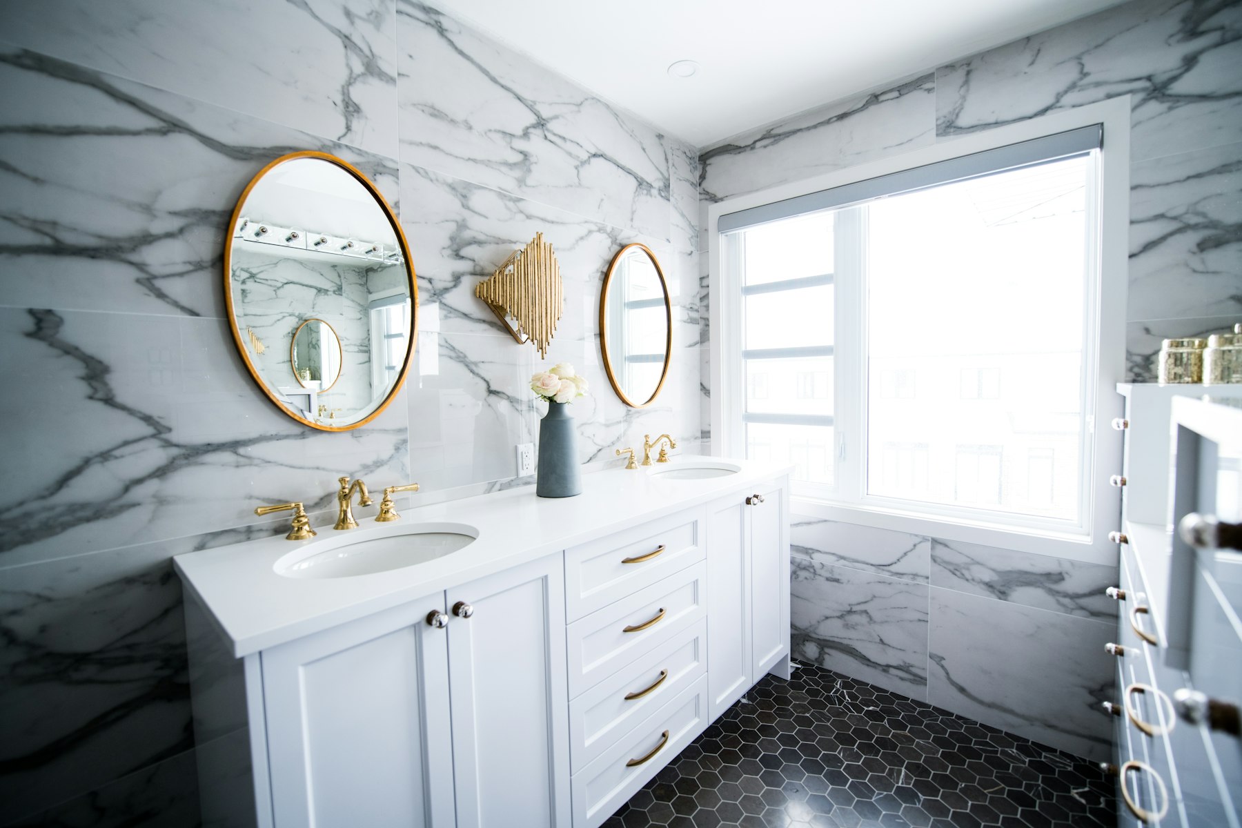 A bathroom with a double vanity and clean modern fixtures, representative of a full bathroom remodel