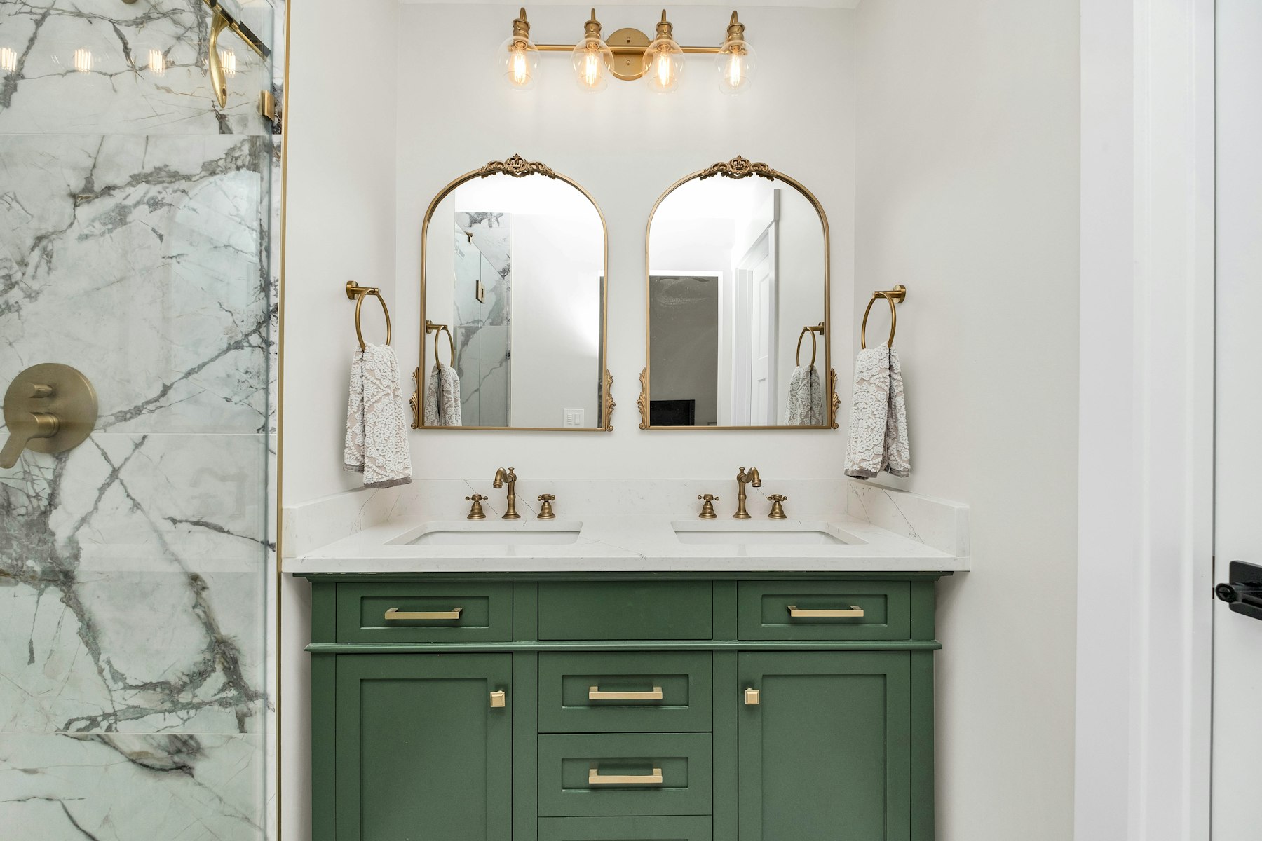 Elegant bathroom vanity with green marble and brass fixtures, representative of our bathroom remodel and refinishing work