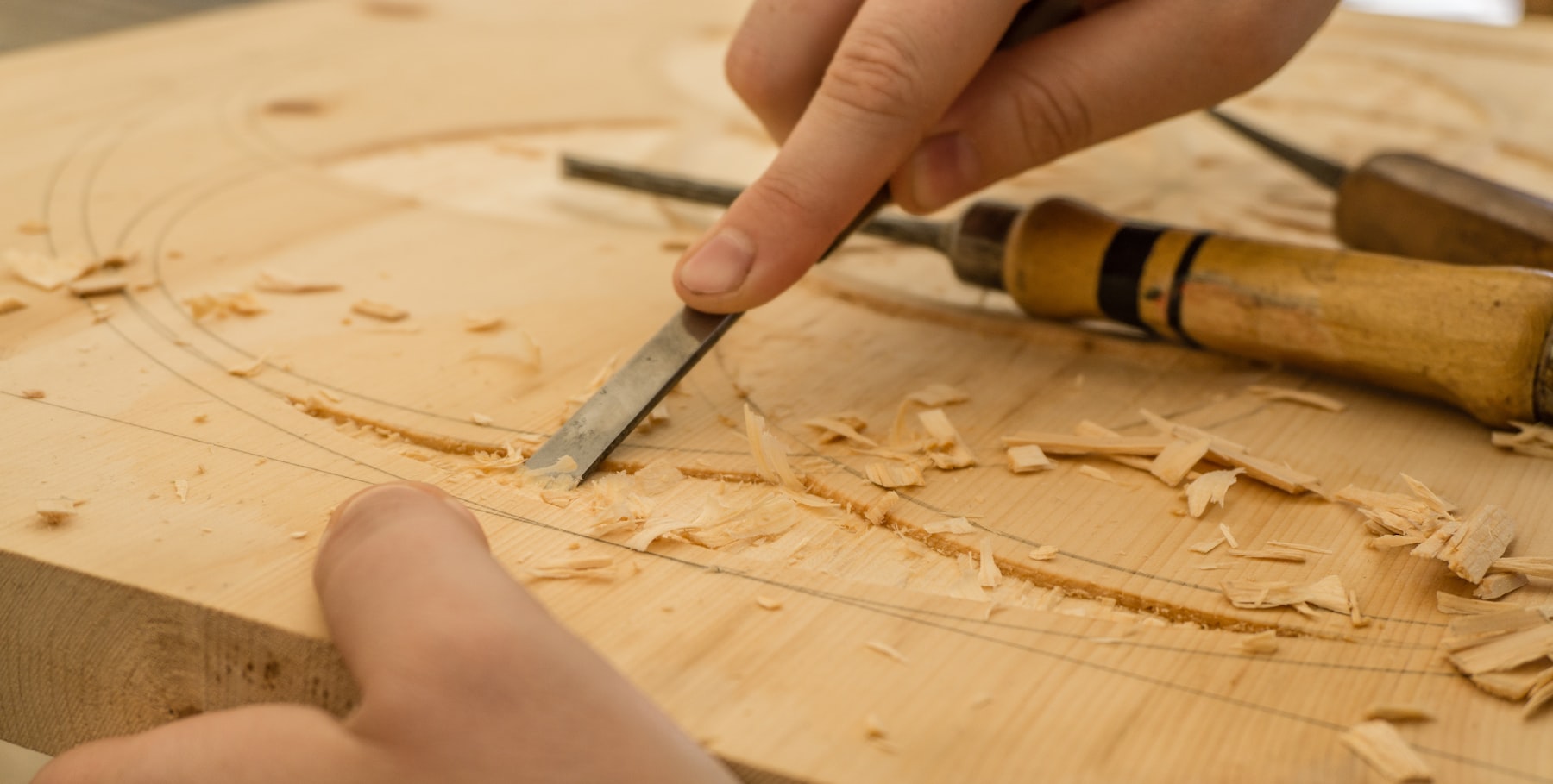 Close view of a chisel shaping wood by hand