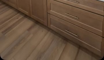 Lower kitchen cabinetry with brushed-nickel pulls and wood-look flooring, from Magnolia Austin's full kitchen remodel